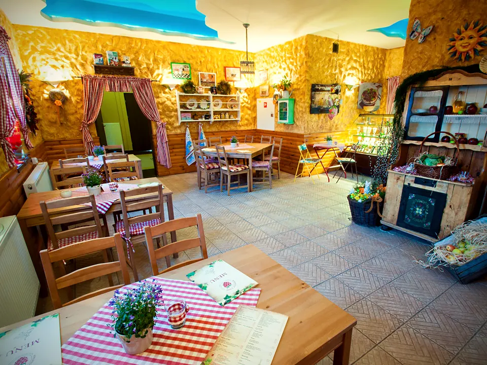 Bistro z niebem namalowanym na suficie i obrusami w czerwoną kratę