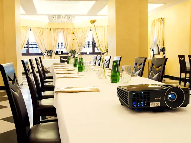 Projektor na stole konferencyjnym, w tle sala