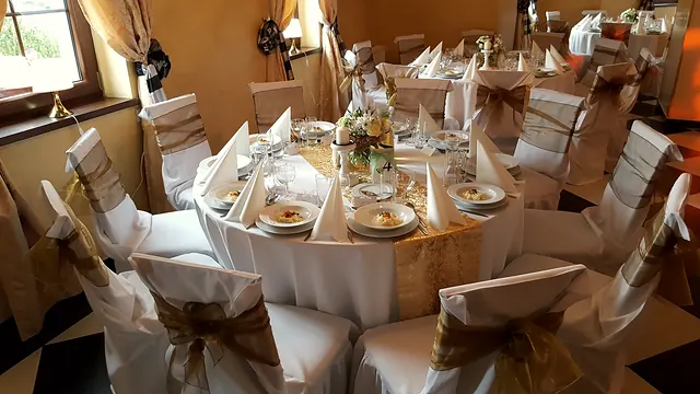 Stół w stylu rustykalnym, krzesła przewiązane jutowymi szarfami