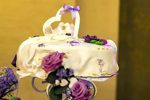 Biały tort weselny z fioletowymi różami z cukru